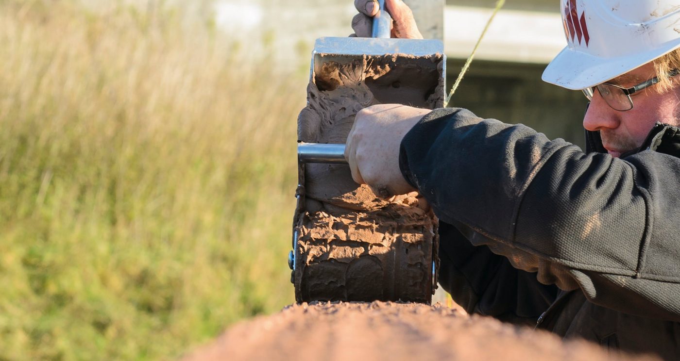 Bouwvakker die PLS binnenmuurstenen verlijmt