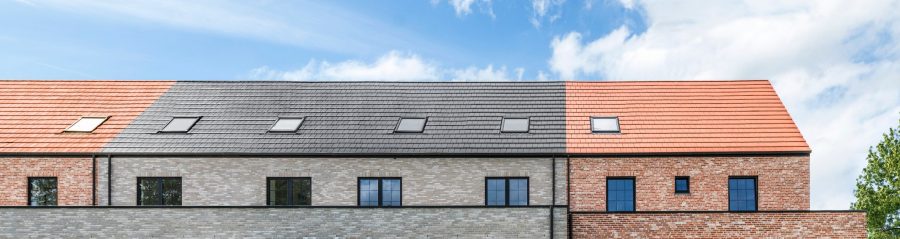 Afbeelding van geschakelde woningen waarbij zowel rode als zwarte dakpannen op het dak werden toegepast
