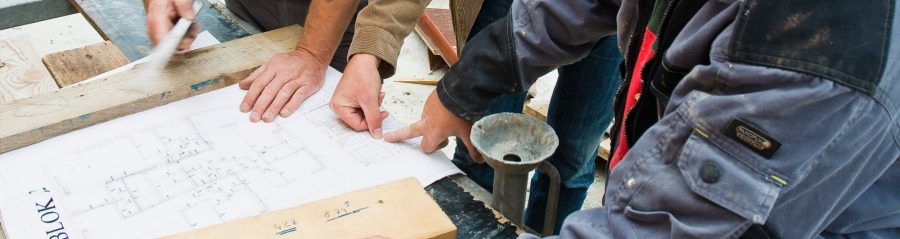 People discuss a construction plan on a yard 