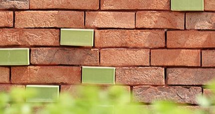 Zacht wildverband van traditionele gevelstenen i.c.m. geglazuurde gevelstenen die uitsteken in het gevelvlak