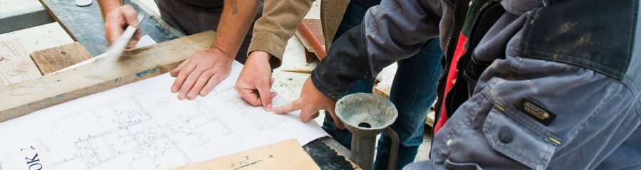 People discuss a construction plan on a yard 