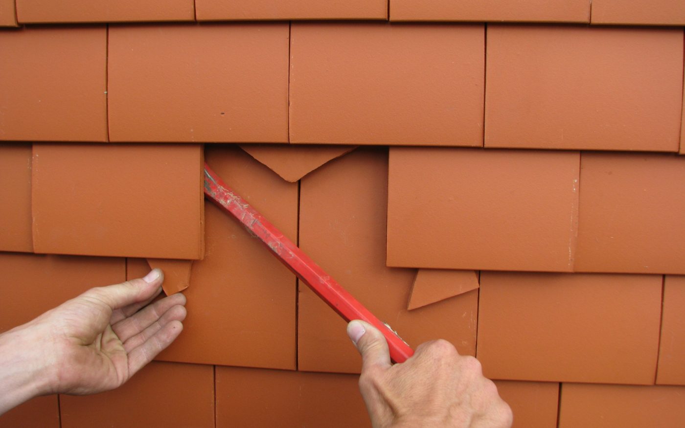 2. Glissez des cales sous les tuiles voisines, pour avoir plus de jeu (par ex. au moyen des morceaux de la tuile cassée.)